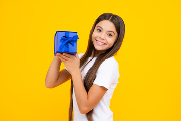 Happy teenager portrait. Emotional teenager child hold gift on birthday. Funny kid girl holding gift boxes celebrating happy New Year or Christmas. Smiling girl.
