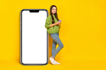 Full size profile side photo of young girl use mobile gadget app download web presenting isolated over yellow color background