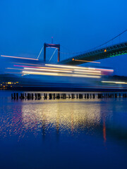 Ferry passing bridge in evening light