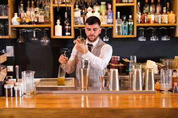 Bartender preparing a cocktail to surprise his clients. Concept: style, alcoholic drinks, enjoy.
