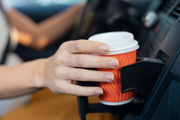 Fototapeta na wymiar Woman driver drinking coffee while travel by car