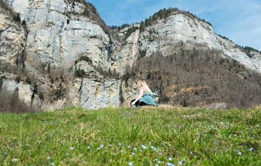 blonde girl looking up to the massive Seerenbach waterfalls at Walensee