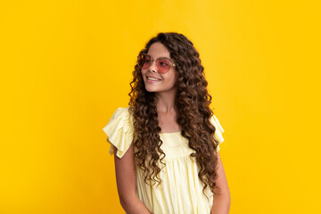 Happy teenager, positive and smiling emotions of teen girl. Children studio portrait on yellow background. Childhood lifestyle concept. Cute teenage girl face close up.