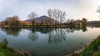 Bend of the ADDA river in the territory of Brivio in Lombardy (Italy) on an early spring afternoon. - 583261728