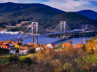 Puente colgante sobre el mar entre monta&ntilde;as con casas y &aacute;rboles. Puente de Rande. R&iacute;a de Vigo. Galicia.