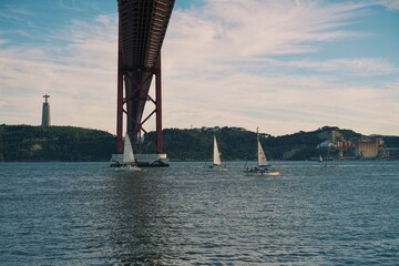 April 25 Bridge on the Tagus River in Lisbon, Portugal. In the background is a statue of Jesus Christ.