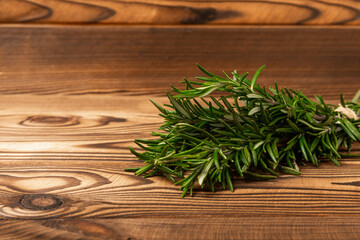 Fresh rosemary herb on a brown tree.Bunch of fresh fragrant rosemary. Spices and herbs for meat and fish. Recipe. Culinary concept. Space for text. Space for copy. Flat lay.