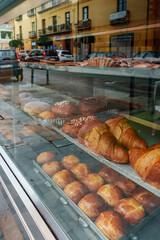 Fresh pastries behind the glass of a cafe on the street.