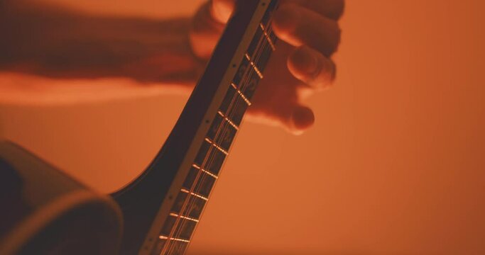 Close up of a musician playing an acoustic f-style mandolion
