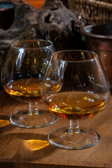 Tasting of aged french cognac brandy alcoholic drink in old cellars of cognac-producing regions Champagne or Bois, France
