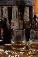 Speyside scotch whisky tasting on old dark wooden vintage table with barley grains close up
