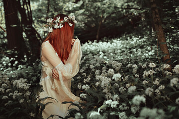 Red haired woman in forest full of white flowers
