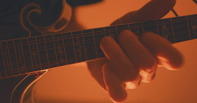 Close up of a musician playing an acoustic f-style mandolion