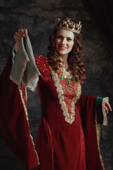happy medieval queen in red dress with handkerchief and crown