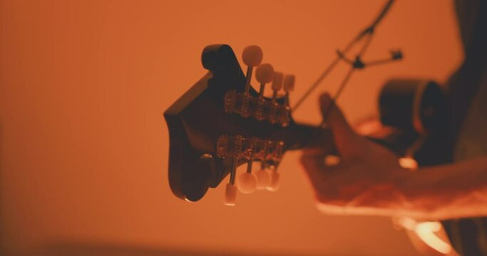 Close up of a musician playing an acoustic f-style mandolion