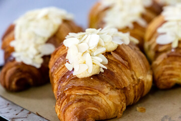 A lot of ready almond-flavored croissants in a bakery