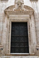 The entrance door to the Purgatory Church, decoration with grim reapers in Monopoli, Italy.