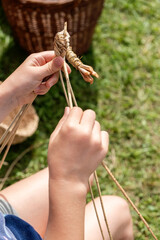 Basket weaving craft. Children's hands close up.