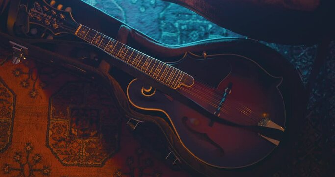 Close up of a musician picking up a mandolin from a hard case
