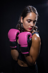 Dark Haired Girl Boxing a Punching Bag in a Moody Setting