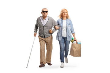 Woman helping a blind senior man with grocery bags