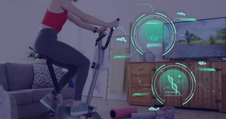 Animation of data processing over caucasian woman exercising, using stationary bike at home