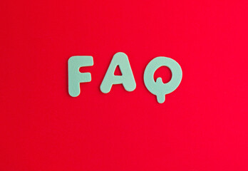 Colored letters as FAQ abbreviation frequently asked questions on red background with copy space.