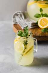 Homemade lemonade with fresh lemon slices and mint leaves in a glass. A summer refreshing drink.