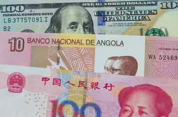 A Chinese Yuan Note With An American One Hundred Dollar Bill With Money From Angola - obrazy, fototapety, plakaty