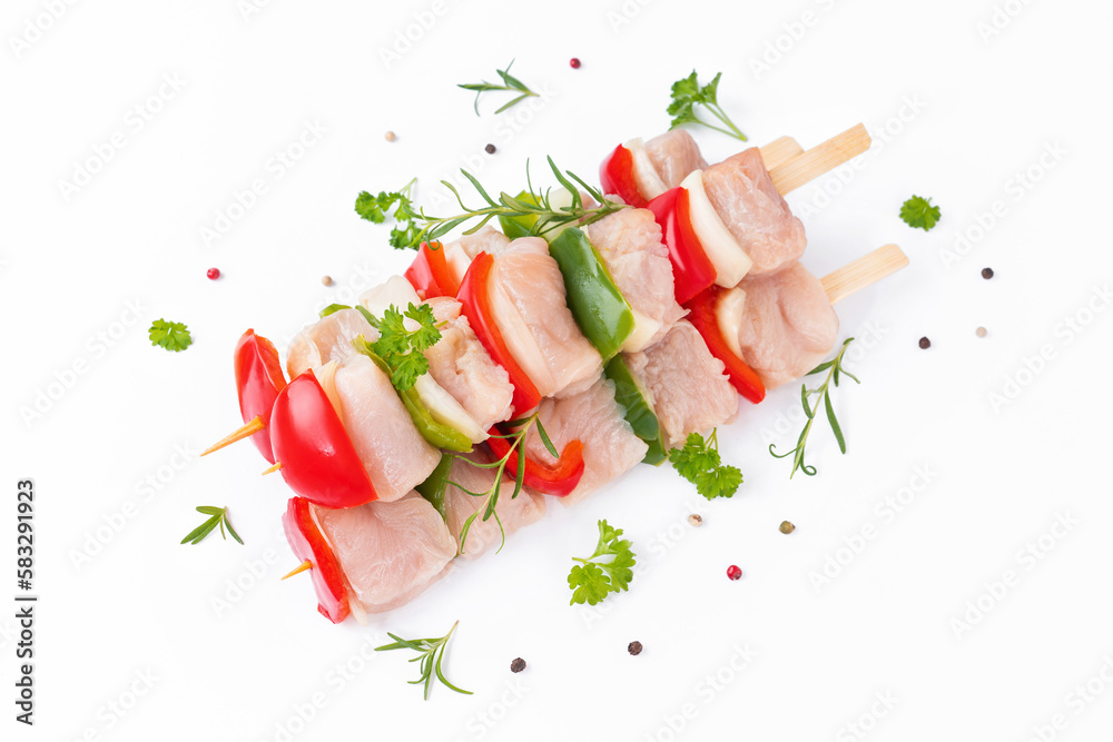 Wall mural Skewers with pieces of raw meat, red, and green pepper, on white background.Uncooked mixed meat skewer with peppers.Raw turkey skewers with vegetables, peppers, onions on a white background.Top view.