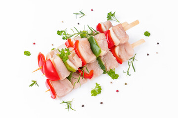 Skewers with pieces of raw meat, red, and green pepper, on white background.Uncooked mixed meat...