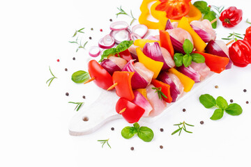Chicken Skewers meat.Raw chicken leg meat skewers with vegetables,peppers, onions,white background.Uncooked mixed meat skewer with peppers.Skewers with pieces of raw meat, red, yellow pepper.Top view.