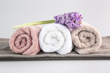 Clean soft towels and hyacinth flower on grey background