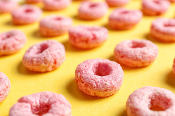 Many pink cereal rings on yellow background