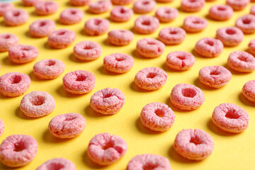 Many pink cereal rings on yellow background