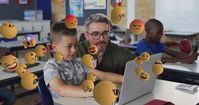 Animation of emoji icons over diverse schoolchildren with male teacher using laptop