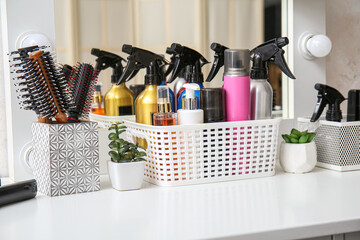 Hair sprays with accessories on table in beauty salon