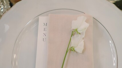 Velvet and pink wedding menu with flowers on plate closeup