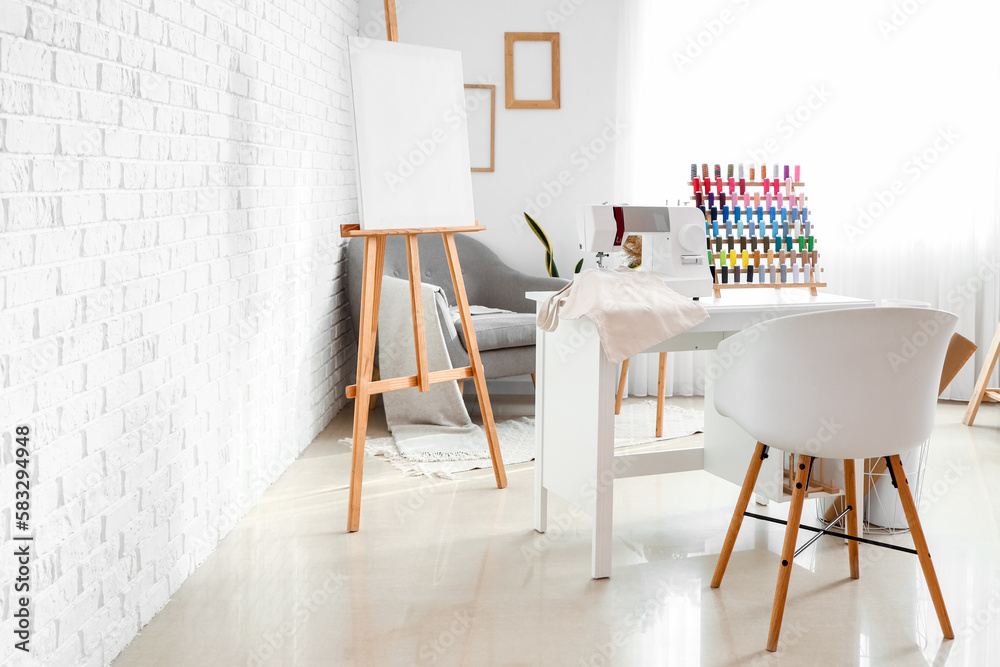 Poster Interior of atelier with tailor's workplace, thread spools and easel