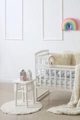 Fototapeta na wymiar Interior of light children's bedroom with baby crib and table