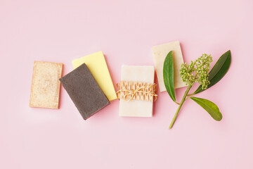 Set of natural soap bars and plant branch on pink background