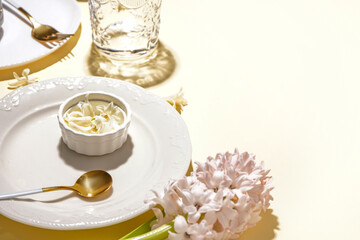 Clean dishes, cutlery and hyacinth flowers on beige background