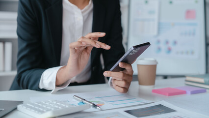 Using mobile cellphone, Close up hands of asian bookkeeper female working with stack of papers and balance sheet with bureaucracy hardworking in office desk.