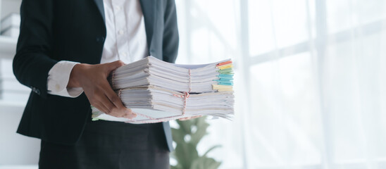 Paper stack, unfinished document, Close up hands of asian bookkeeper female working with stack of papers and balance sheet with bureaucracy hardworking in office desk.