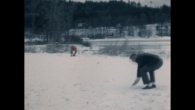 Dad Son Snowball Fight 1965 - A father and his son throws snowballs at each other in the 1960s