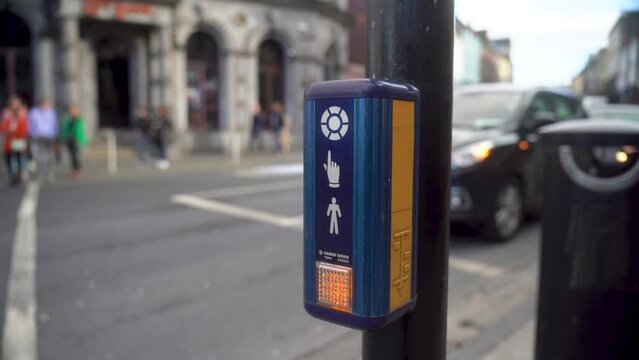 Pressing signal button crossing the street in Ireland Kilkenny