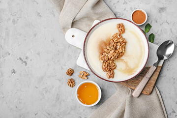 Bowl of tasty semolina porridge with nuts, cinnamon and honey on grunge background