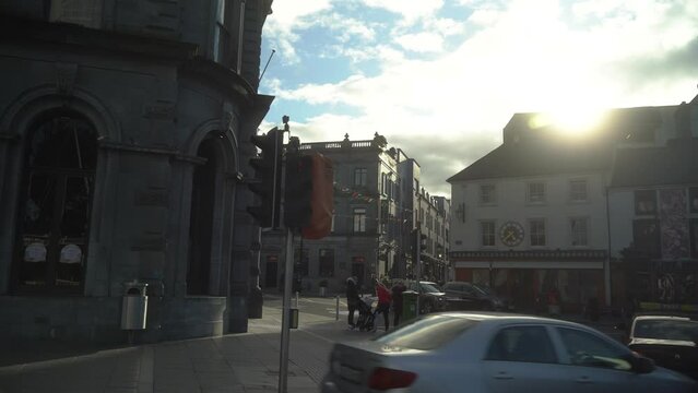 Cars drive by against the backdrop of the ancient city of Kilkenny Ireland. 