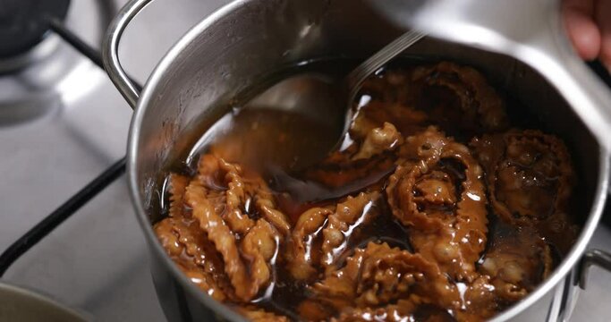 Honey-kissed delights: the chebakia pieces take on a glossy finish as they are lovingly dipped into warm, fragrant honey.