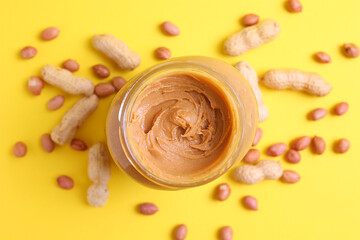 peanut butter and raw peanuts on a colored background